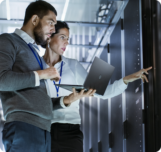Two professionals analyzing data on a transparent screen in a modern office environment.